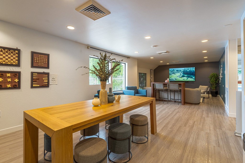a room with a table and chairs with a tv in the background